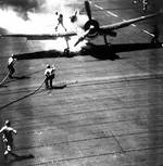 Firefighters extinguishing a burning Hellcat fighter on Cowpens, 24 Nov 1943
