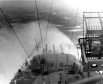 Battleship Indiana taking water over the bow while sailing through a typhoon in the Okinawa, Japan area, circa 5 Jun 1945