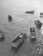 Wounded personnel being loaded from USS Intrepid into waiting LCVP landing craft, probably at Ulithi, Caroline Islands, 1944, photo 1 of 2