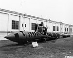 A Kairyu-class submarine in cutaway form at Yokosuka Naval Base, being examined by Fire Controlman 2nd Class Charles L. Carroll and another American sailor, 11 May 1951