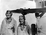 US Navy aviators Ensign William C. Orr and Aviation Radioman 3rd Class Thomas D. Everett of cruiser Louisville posed by their damaged SOC Seagull aircraft, Feb 1945