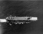 Aerial view of USS Makin Island off Leyte, Philippine Islands, 18 Nov 1944; note lowered forward elevator and FM-2 Wildcat aircraft on the flight deck