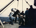 Crewmen hoisting one of USS Miami
