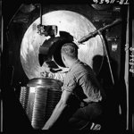 Sailor of American battleship New Jersey lowering the breech block of one of the ship