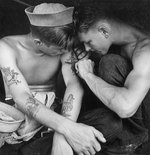 US Navy sailor tattooing a fellow sailor aboard USS New Jersey, Dec 1944