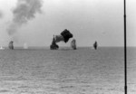 USS Saint Paul bombarding the Cong Phy railroad yard 25 miles south of Thanu Hoa, Vietnam, 4 Aug 1967; note splashes from coastal gun batteries