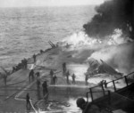Following an attack from Japanese special attack aircraft, fires grew in the forward hangar deck of USS Saratoga off Iwo Jima, 21 Feb 1945. The fires increased greatly before they could be controlled. Photo 2 of 3