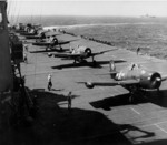 F6F Hellcat aircraft preparing for takeoff from Ticonderoga for strikes in Manila Bay, Philippine Islands, 5 or 6 Nov 1944; note two leading planes were F6F-5N nightfighters with wing-mounted radar