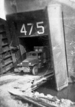 US Army CCKW 2 1/2-ton 6x6 cargo truck carrying airfield support supplies exiting USS LST-475 beached at Yokohama, Japan, 13 Sep 1945; the ship was the first LST landing in Japan after surrender