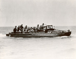 Older DUKW of HQ Company of US Army Amphibious Training Center loaded with troops during training exercise, date unknown; note straight windscreen and manual bilge pump on foredeck next to shovel