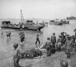 African-American soldiers of a port battalion of the US 5th Army unloading supplies at the beach at Salerno, Italy, 18 Sep 1943; note DUKW in center and fresh water cans marked with 
