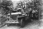 Japanese-American troops in a jeep in the Chambois Sector in France, circa Oct 1944; note anti-decapitation device on front bumper