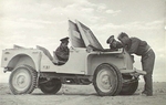 Members of the No. 3 Squadron RAAF checking under the hood of a Bantam BRC 40 Jeep in Libya
