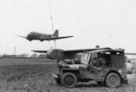 C-47 Skytrain with hook lowered preparing to snatch CG-4 glider as the Control Team stands by in a GPW/MB Jeep, date unknown
