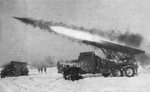 Soviet BM-13 Katyusha rocket launcher mounted on a ZiS-151 truck firing a rocket, 1960s; note BM-21 rocket launcher at left
