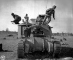 Corporal Larry Corletti, Private Murril Chapman, and Private Louis Robles practicing abandoning a M3 medium tank at Camp Polk, Louisiana, United States, 12 Feb 1943