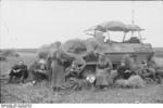 German troops resting beside a camouflaged SdKfz. 251/3 halftrack vehicle, Russia, Sep 1941