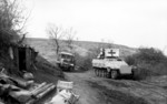 German SdKfz. 251 halftrack vehicle and truck on a dirt road, Italy, 1944; note red cross emblems on the halftrack vehicle