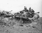 American troops posing atop one of two knocked-out StuG III Ausf G assault guns near Modrath, Germany, 1945; the vehicles were disabled by US 9th Air Force fighter-bombers