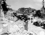 US Army convoy passing through the remains of Saint-Lô, France during the Normandy invasion, 29 Jul 1944; note Jeeps, CCKW 2-1/2 ton transports, Studebaker M29 Weasel, and Dodge WC54 field ambulance