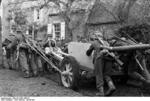 German troops moving a 7.5 cm PaK 40 anti-tank gun across a muddy road in Northern France, Oct 1943; note Kar98k rifles