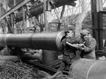Female worker being helped out of a BL 15 in gun after she had finished cleaning the rifling, Coventry Ordnance Works, England, United Kingdom, 1914-1918