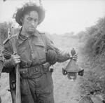 Lance Corporal Lodge of 278th Field Company, British Royal Engineers holding a captured German 3 HL shaped charge, near Caen, France, 26 Jun 1944