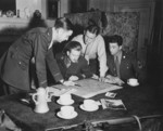 Allied Operation Jedburgh personnel receiving instructions from a briefing officer, London, England, United Kingdom, circa 1944; note M1 Carbine on table