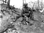 Private First Class Julias Van Den Stock of Company A, 32nd Regimental Combat Team, US 7th Infantry Division with M1 or M2 Carbine with captured Communist Chinese DP light machine gun and RPG-43 grenade on Hill 902, near Ip-Tong, Korea, 25 Apr 1951