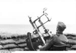 German soldier on the French coast with a twin MG34 machine gun anti-aircraft mount, 1943