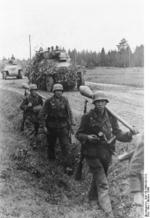 German Großdeutschland Division troops on a road at Memel, East Prussia, Germany, Oct 1944; note Panzerfäuste, Kar98k rifles, and grenades