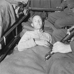 William Joyce in an ambulance under armed guard with a thigh gunshot wound, Flensburg, Germany, 29 May 1945, photo 2 of 3
