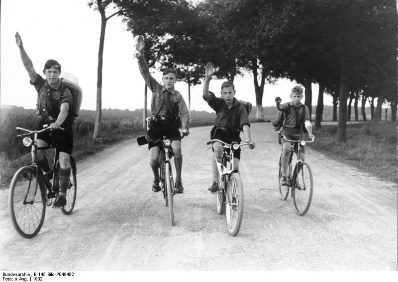 Members of Hitler Youth giving the Nazi Party salute on their bicycles, near Berlin, Germany, 1932