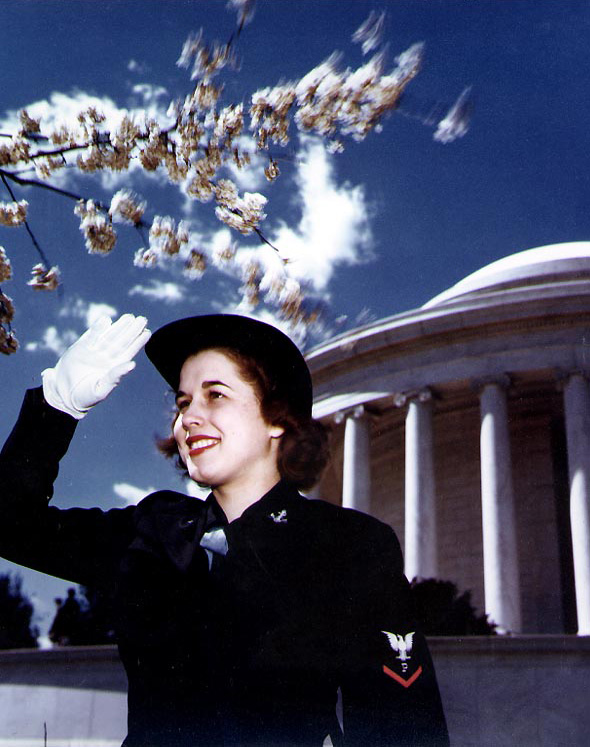 WAVES Specialist (P) 3rd Class saluting near the Jefferson Memorial, Washington, DC, United States, during WW2; note the cherry blossoms, indicating the photograph was taken in the spring