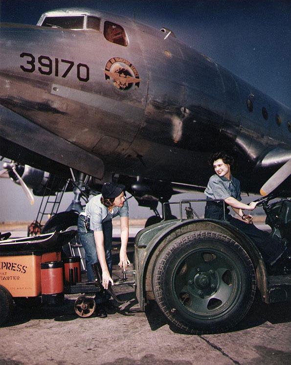 WAVES Seamen 1st Class Billy Ikard and Barbara A. Patterson moving a battery cart into position next to a R5D Skymaster aircraft, Naval Air Station, Oakland, California, United States, circa mid-1945