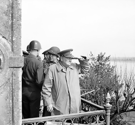 Winston Churchill and American generals on a balcony watching Allied vehicles crossing the Rhine River into Germany, 25 Mar 1945