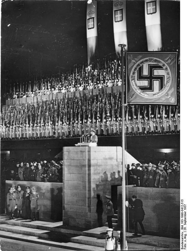 Goebbels speaking during Mussolini's visit to Berlin, Germany, 28 Sep 1937; Mussolini, Ciano, Göring, and Hitler standing beneath the grandstand