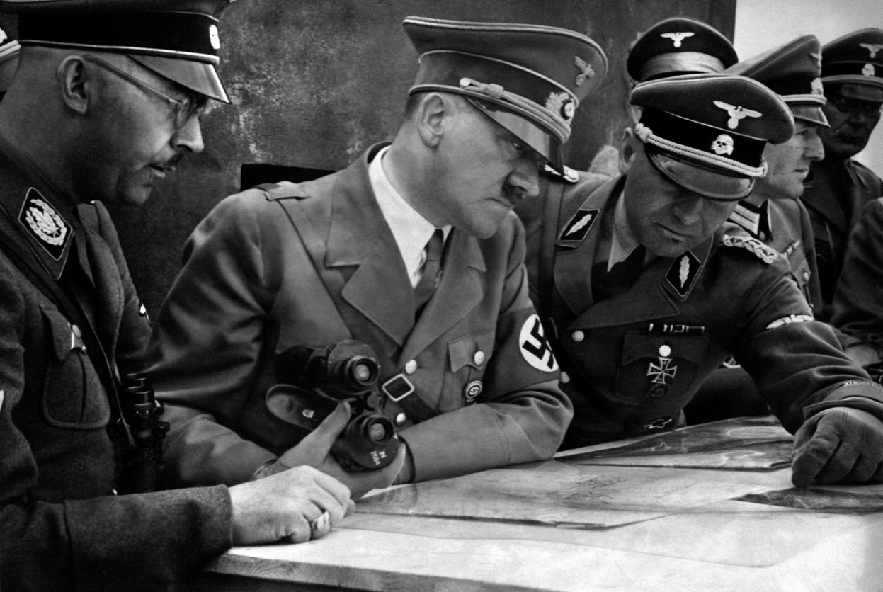 A German SS-Standartenführer showing troop dispositions on a map to Himmler and Hitler, 1939