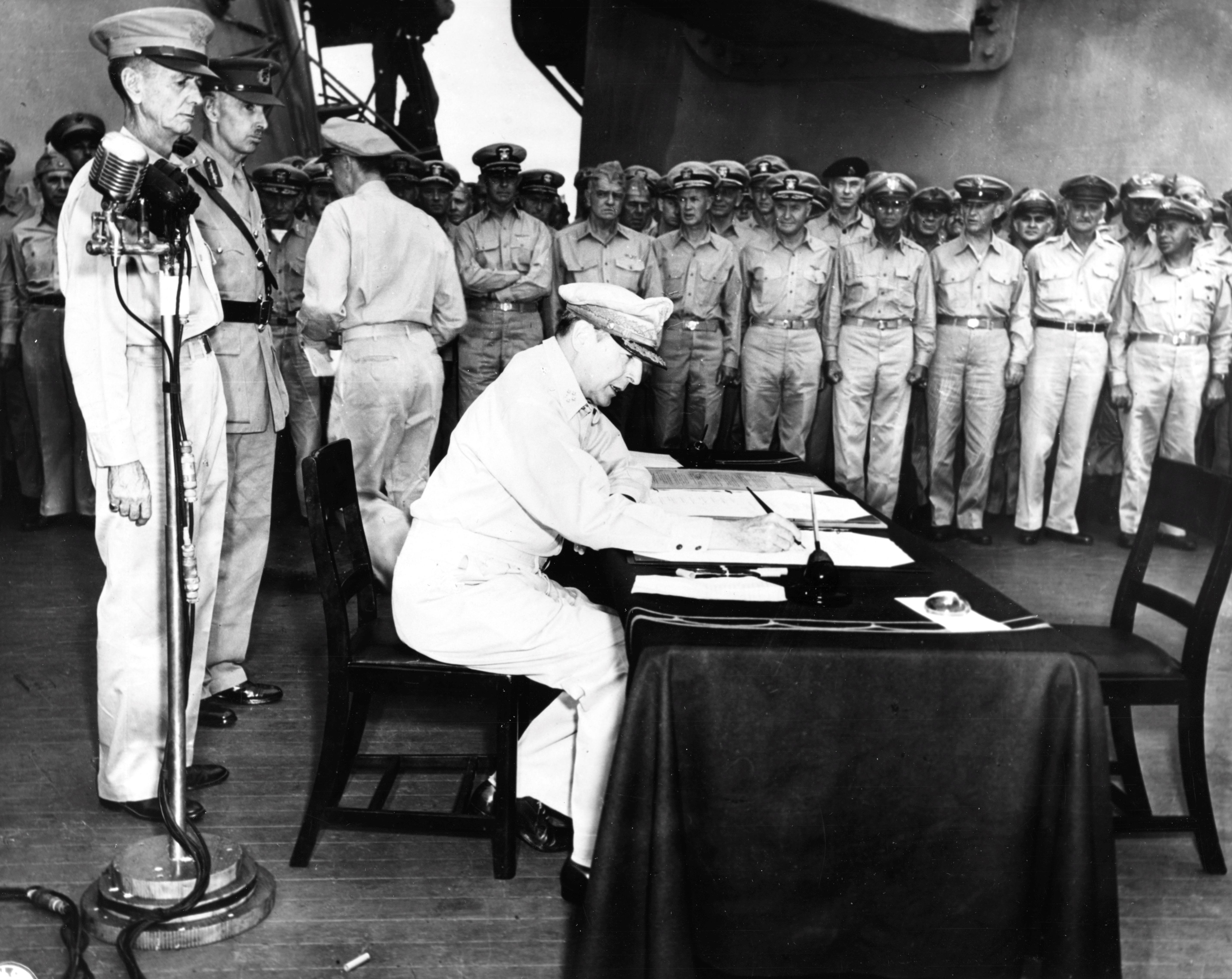 MacArthur signing Japanese surrender aboard USS Missouri, 2 Sep 1945, photo 1 of 4