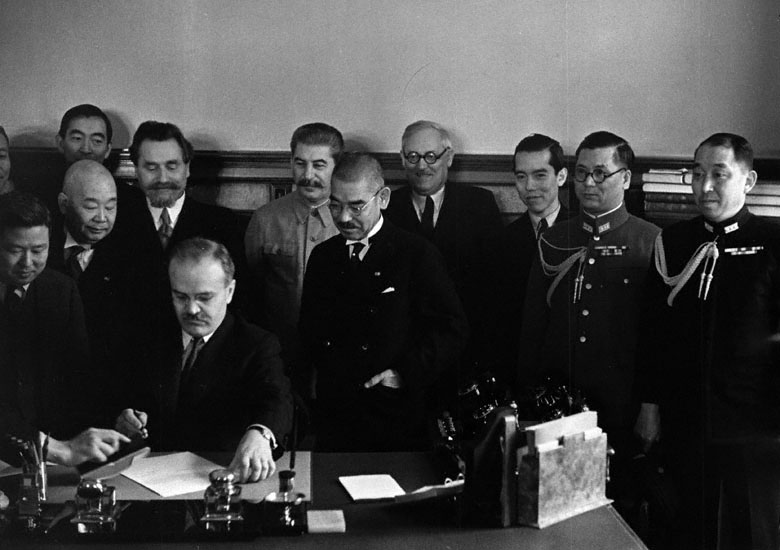 Soviet Foreign Minister Vyacheslav Molotov signing the Soviet-Japanese Neutrality Pact, Moscow, Russia, 13 Apr 1941; note Yosuke Matsuoka and Joseph Stalin in background