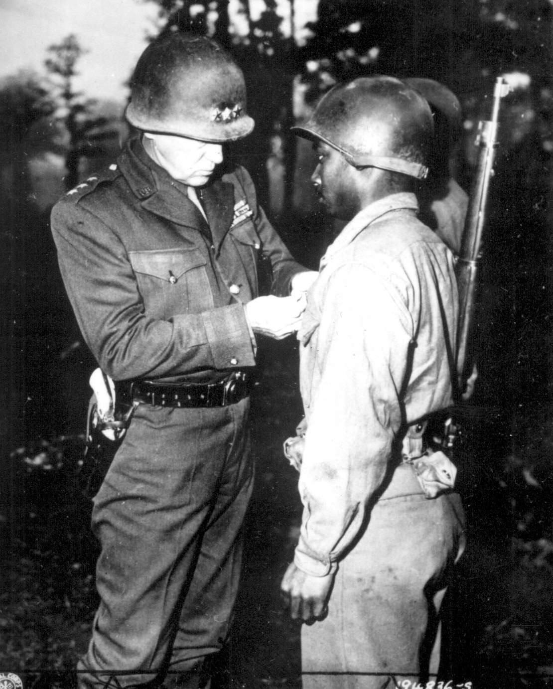Lieutenant General Patton of the US 3rd Army awarding the Silver Star medal to Private Ernest Jenkins for gallantry during actions at Chateaudun, France, 13 Oct 1944