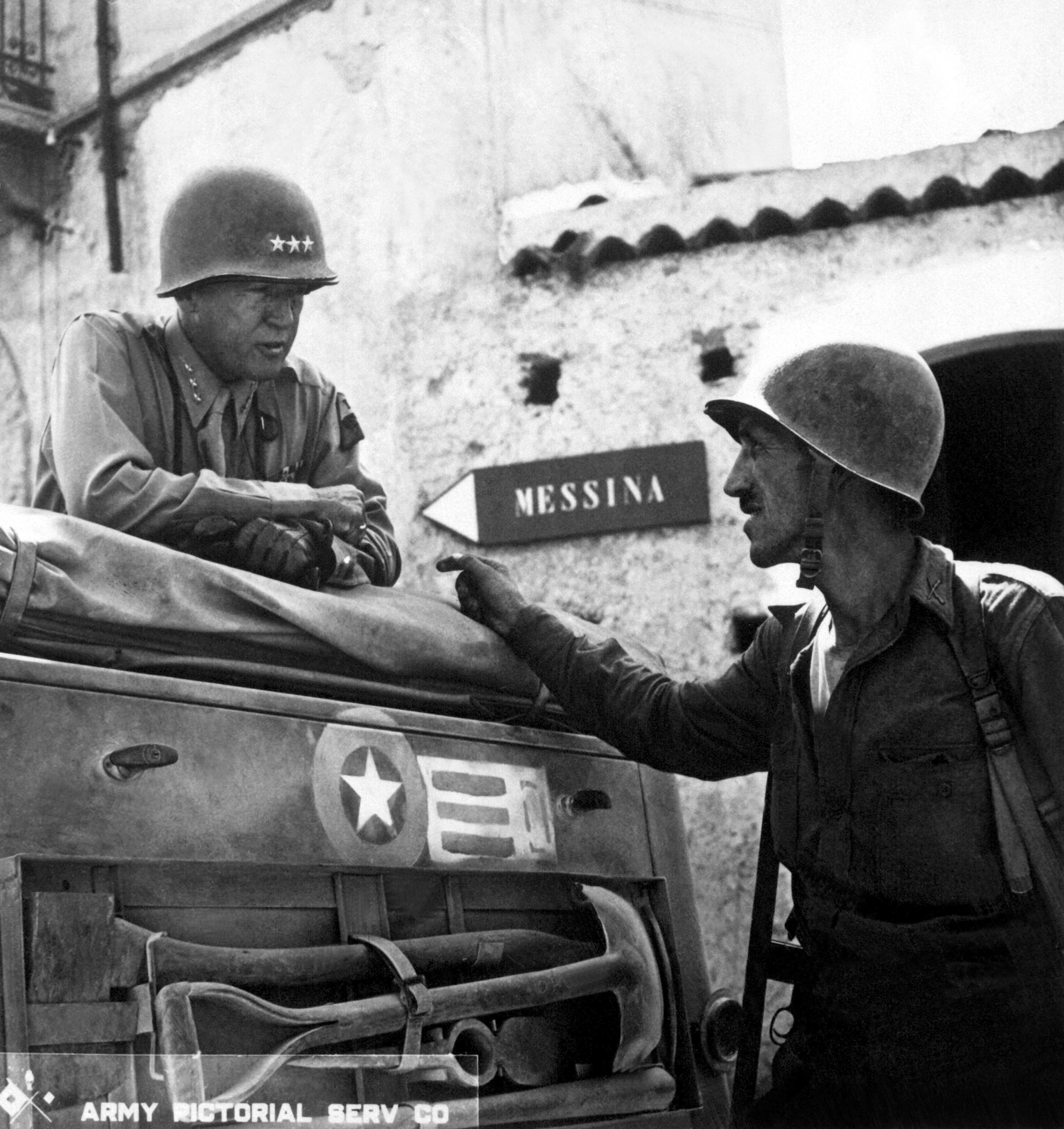 George Patton and Lieutenant Colonel Lyle Bernard, CO, 30th Infantry Regiment discussing strategy near Brolo, Sicily, Italy, circa Jul-Aug 1943