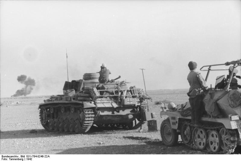 Colonel General Rommel observing smoke on the horizon in his SdKfz. 250/3 command vehicle 'Greif', North Africa, 1942; note Panzer III tank just ahead of his vehicle