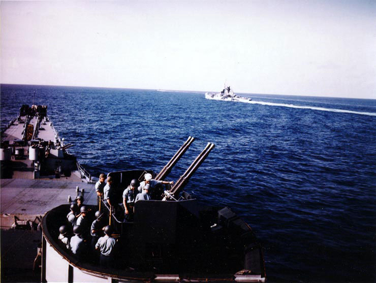 Missouri's 40mm quad anti-aircraft machine crew at battle stations atop turret number two during her shakedown, Aug 1944; Alaska in background
