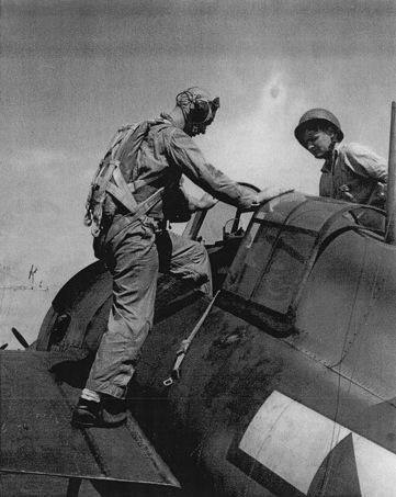 Lieutenant (jg) Lewis entering a F4F Wildcat fighter aboard USS Anzio, Pacific Ocean, 23 Feb 1945