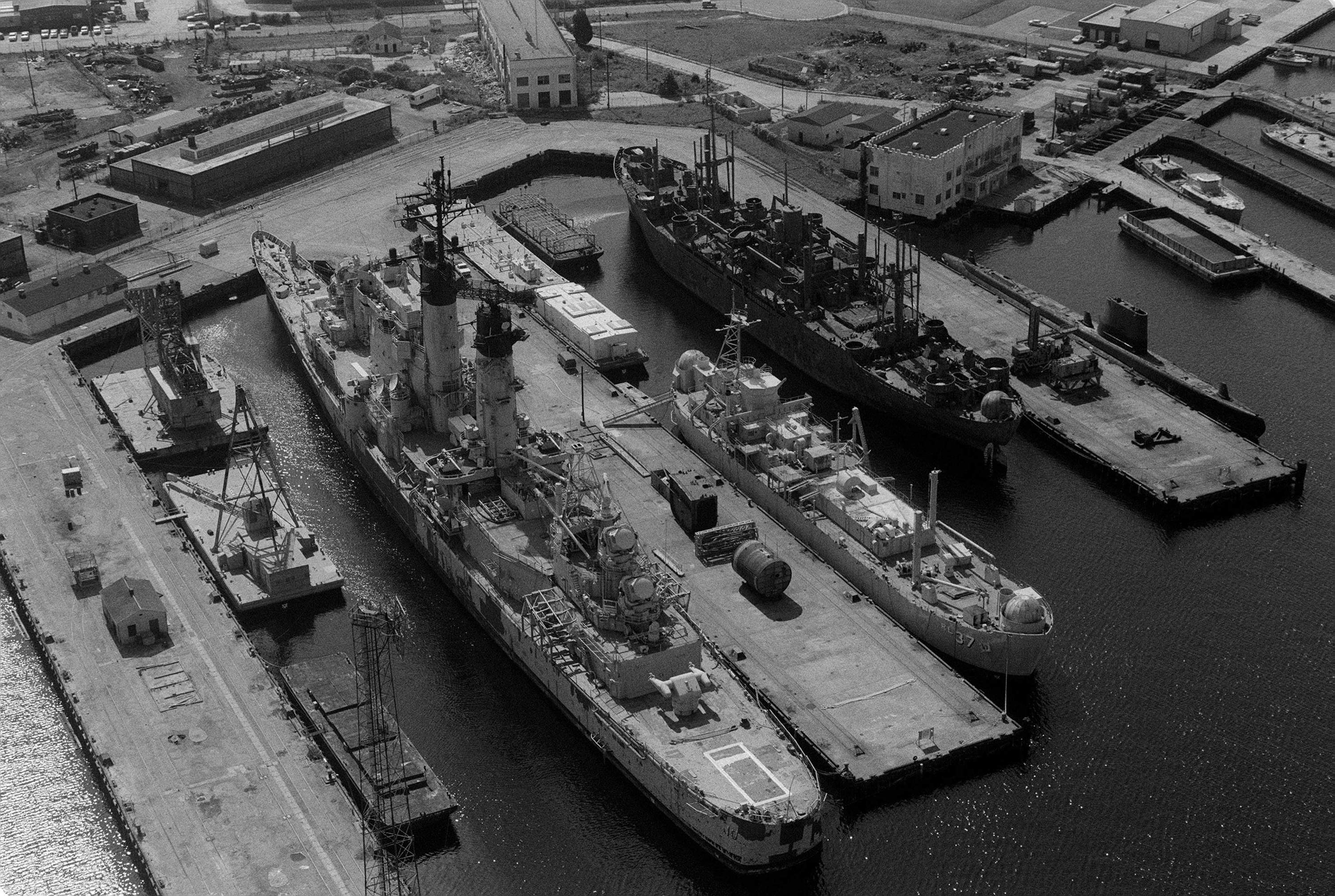 Guided missile cruiser Albany, landing craft repair ship Indira, a Haskell-class attack transport, and submarine Blenny at the St. Helena Annex of Norfolk Naval Shipyard, Virginia, United States, 1 Nov 1983