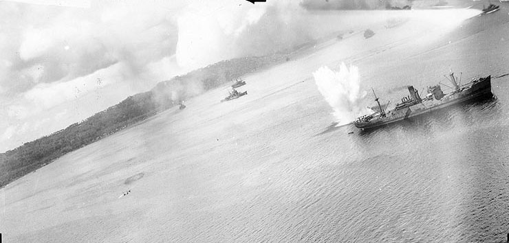 A bomb exploding off port quarter of a Japanese cargo ship in Simpson Harbor, Rabaul, New Britain, 2 Nov 1943; note Haguro in center distance and USAAF 3rd Bomb Group B-25 bomber in lower left; photo 1 of 2
