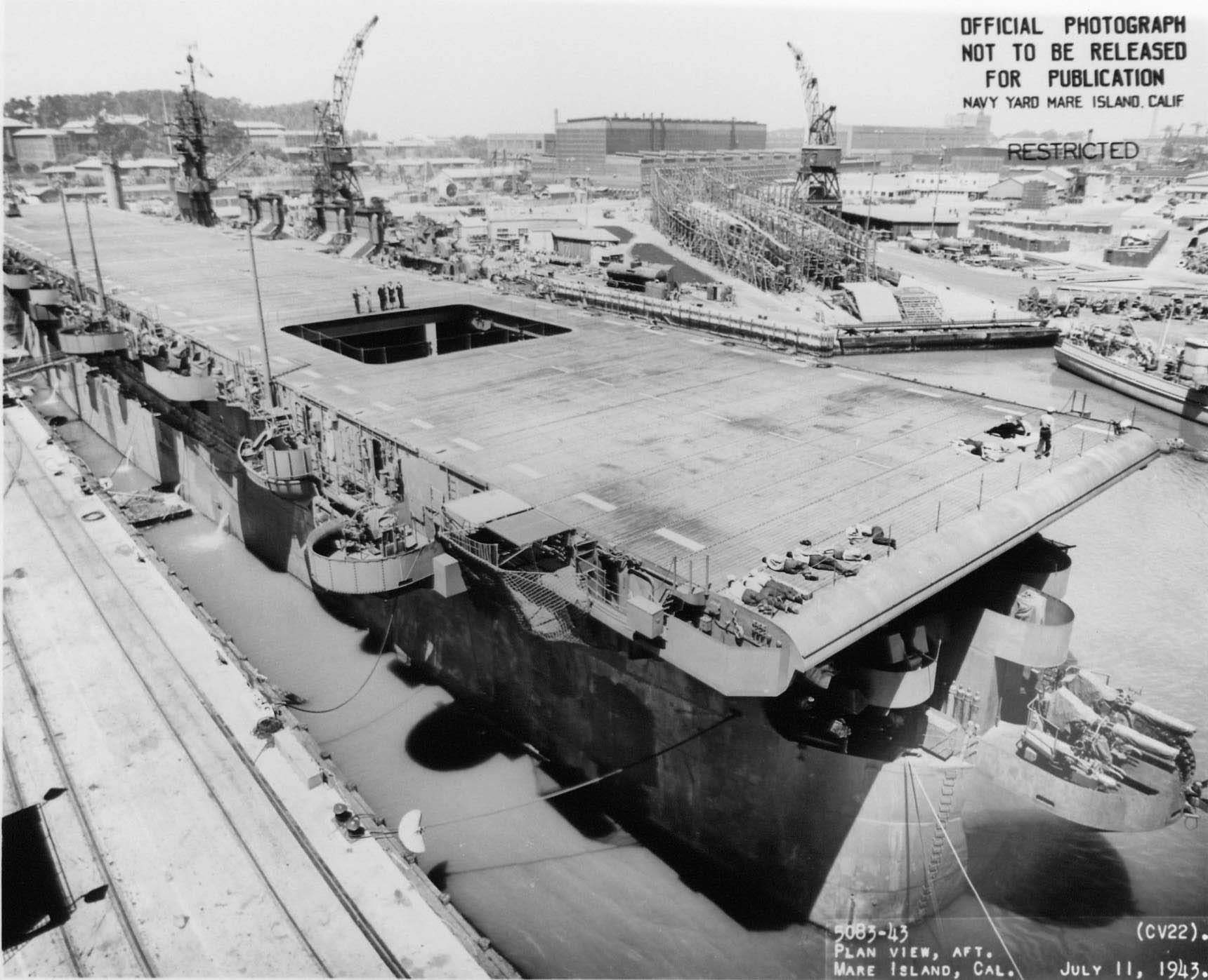Carrier Independence under overhaul at Mare Island Naval Shipyard, California, United States, 11 Jul 1943; note hulls of submarines Spadefish and Trepang nearby