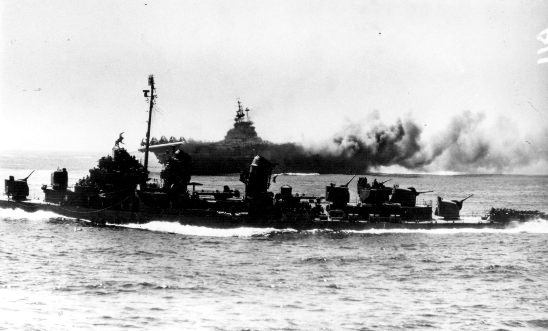 Intrepid burning after special attack, off Okinawa, Japan, 16 Apr 1945; a Fletcher-class destroyer in foreground