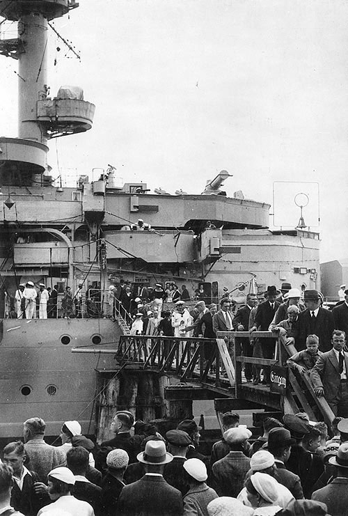 Königsberg's forward superstructure, with visitors on the gangway and on shore in the foreground during an open house at a European port, circa 1930